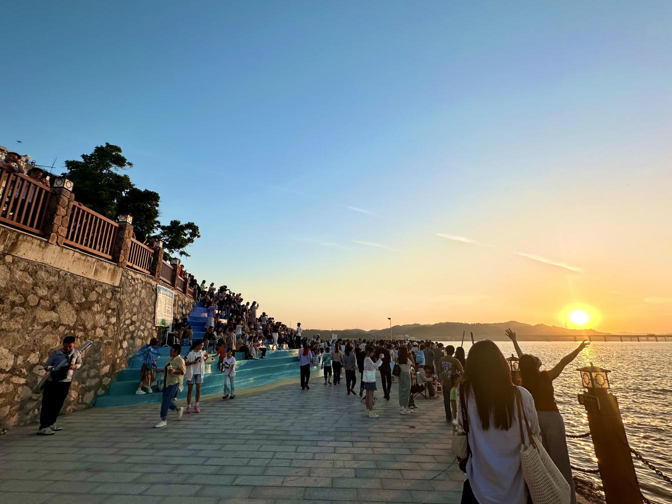 游客在梧州市長洲區(qū)泗洲島鄉(xiāng)村旅遊區(qū)觀賞日落。長洲區(qū)文體旅局 供圖.jpg